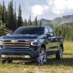 A blue 2023 Chevy Silverado 1500 High Country is shown from the front at an angle.