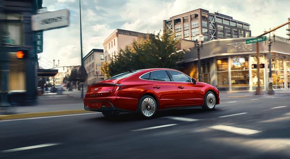 A red 2022 Hyundai Sonata Hybrid is shown from the rear at an angle.