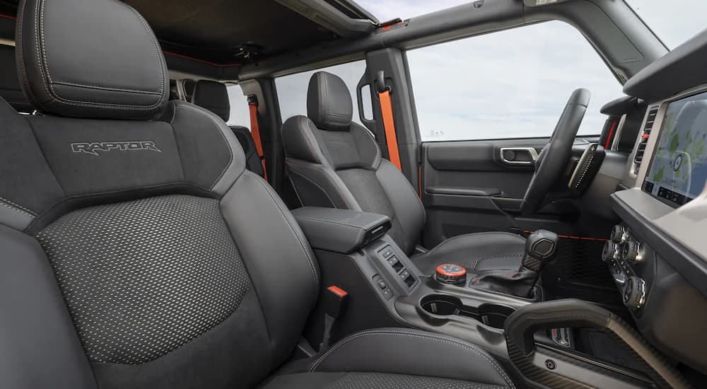 The black interior of a 2023 Ford Bronco Raptor shows the front seating and center console.