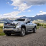 A silver 2023 GMC Sierra 2500HD is shown from the front at an angle during a 2023 GMC Sierra 2500 HD vs 2023 Ford F-250 comparison.