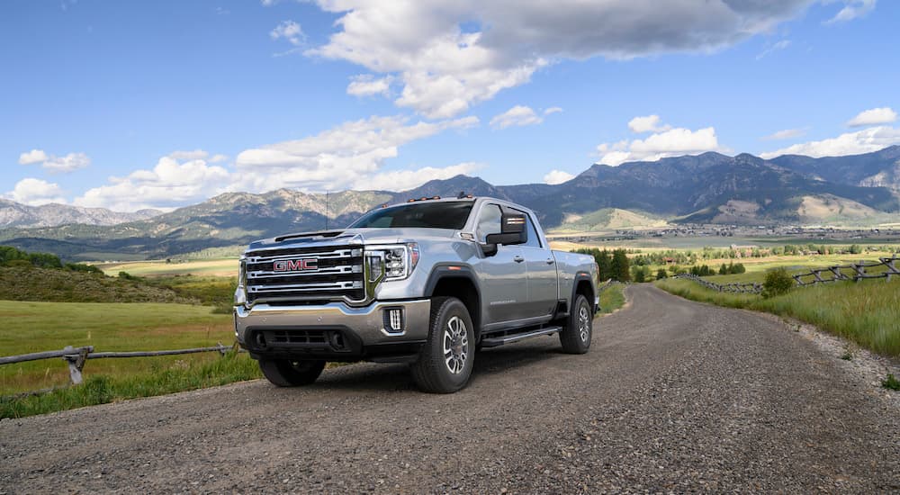 A silver 2023 GMC Sierra 2500HD is shown from the front at an angle during a 2023 GMC Sierra 2500 HD vs 2023 Ford F-250 comparison.