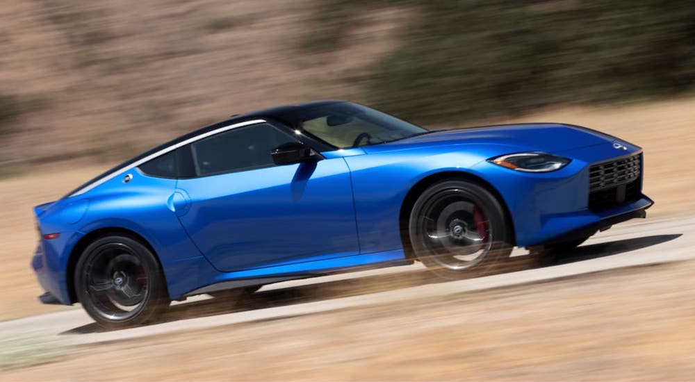 A blue 2023 Nissan Z is shown from the side while driving.