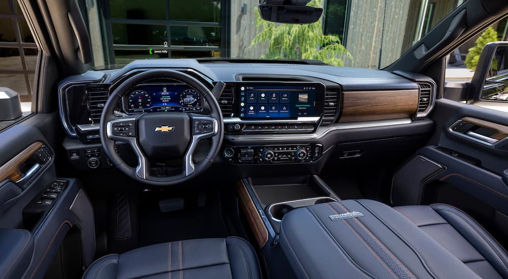 The black interior of a 2024 Chevy Silverado 2500HD High Country is shown from the driver's seat.