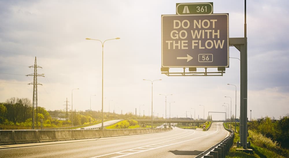 An exit sign is shown on the side of a highway.