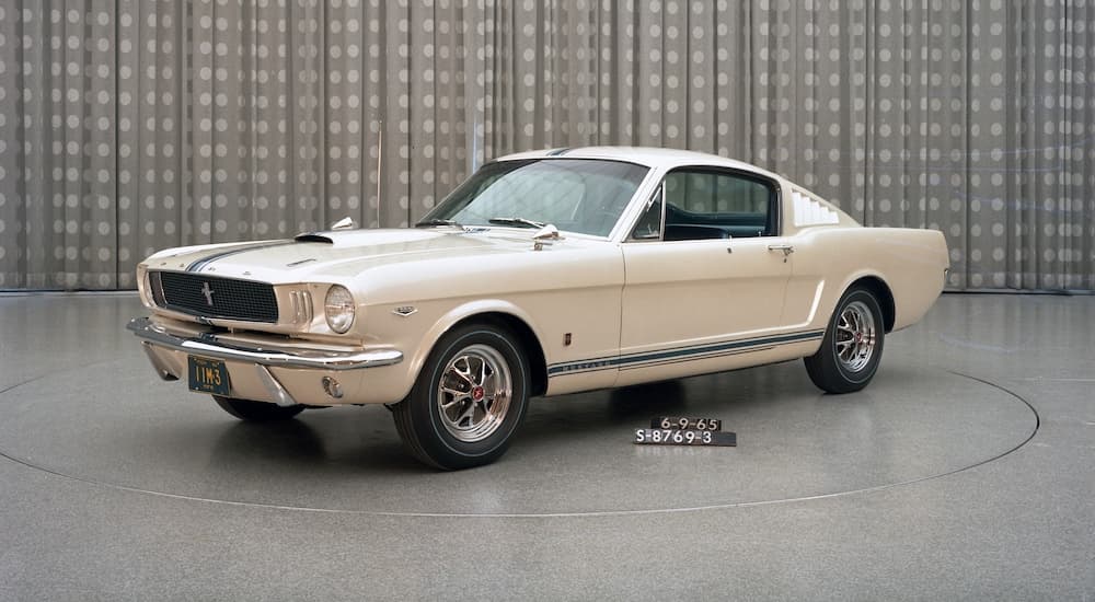 A while 1965 Ford Mustang Shelby GT-350 is shown from the front at an angle.