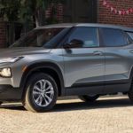 A silver 2023 Chevy Trailblazer is shown from the side parked on the side of a city street.