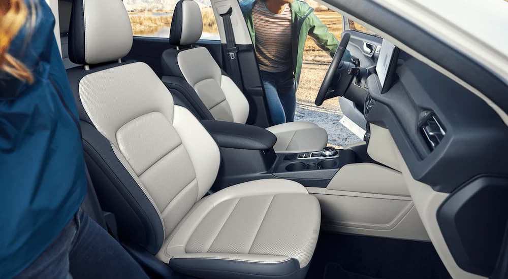The black and grey interior of a 2023 Ford Escape shows the front seats and center console.