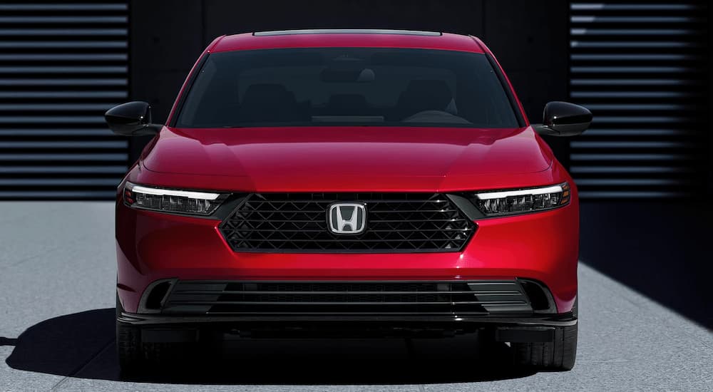A red 2023 Honda Accord Sport Hybrid is shown from the front at a Honda dealer.