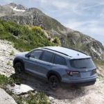 A grey 2023 Honda Pilot Trailsport is shown from the rear at an angle while off-road.