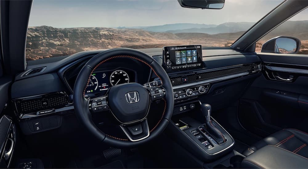 The black interior of a 2023 Honda CR-V is shown from the driver's seat after leaving a dealer that has a Honda CR-V for sale.