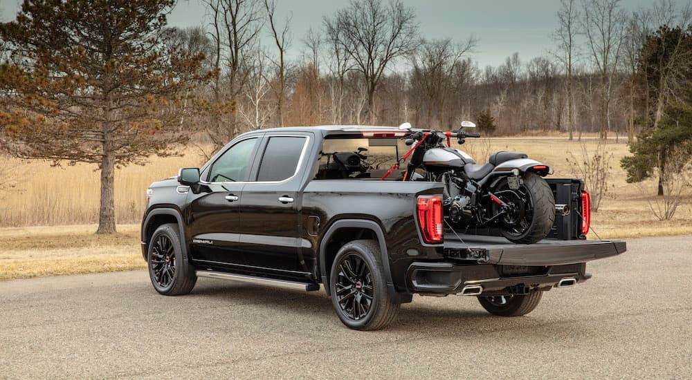 A balck 2020 GMC Sierra 1500 Denali Carbon Pro is shown with a motorcycle in the bed.