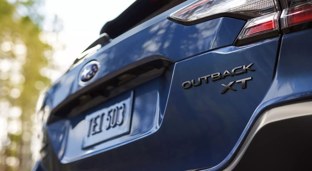 A close up shows the badging on a blue 2023 Subaru Outback XT after leaving a used car dealer near Noblesville.