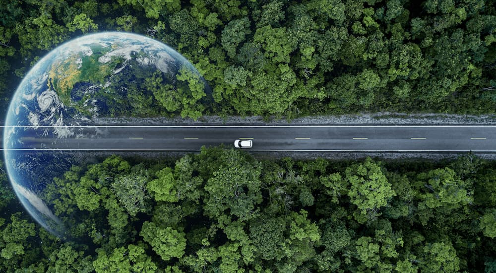 A white vehicle is shown from a bird's eye view above trees.