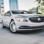 A silver 2017 Buick LaCrosse is shown driving on a winding city street.