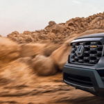 A close up of the front of a black 2022 Honda Passport Trailsport is shown after leaving a used Honda dealer.