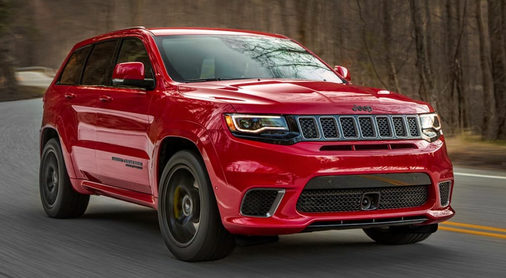 A red 2020 Jeep Grand Cherokee Trackhawk is shown from the front at an angle after leaving a dealer that has a used Jeep Grand Cherokee for sale.