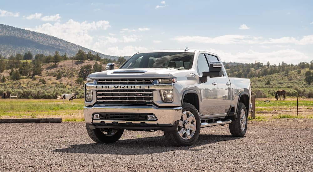 A silver 2023 Chevy Silverado 2500 HD is shown from the front at an angle during a 2023 Chevy Silverado 2500 HD vs 2023 Ford F-250 comparison.