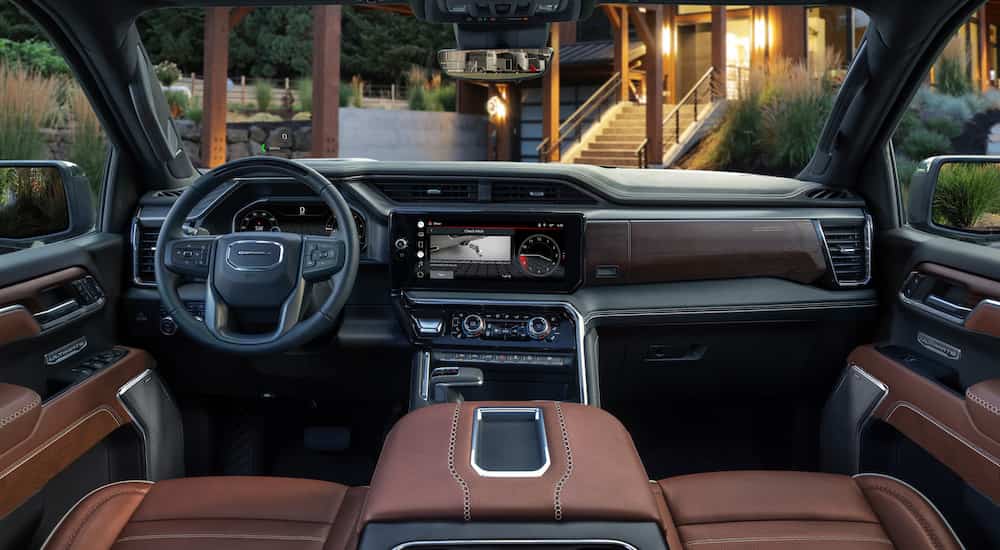 The brown interior of a 2023 GMC Sierra 1500 Ultimate is shown from above the center console.