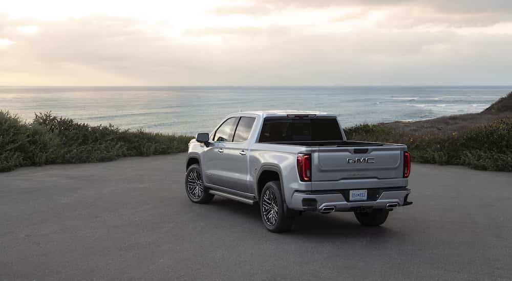 A silver 2023 GMC Sierra 1500 Denali Ultimate is shown from the rear at an angle.