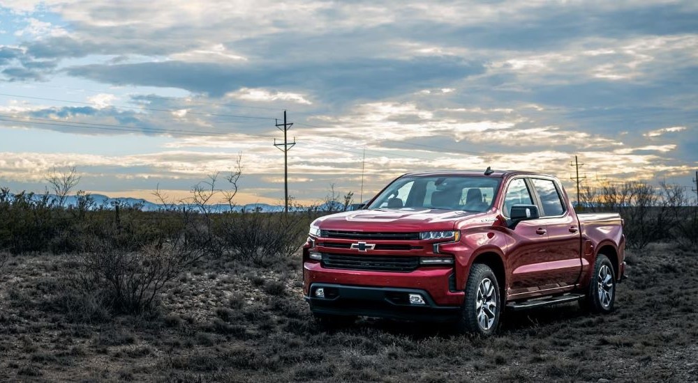 A red 2023 Chevy Silverado 1500 RST Rebel is shown parked off road.