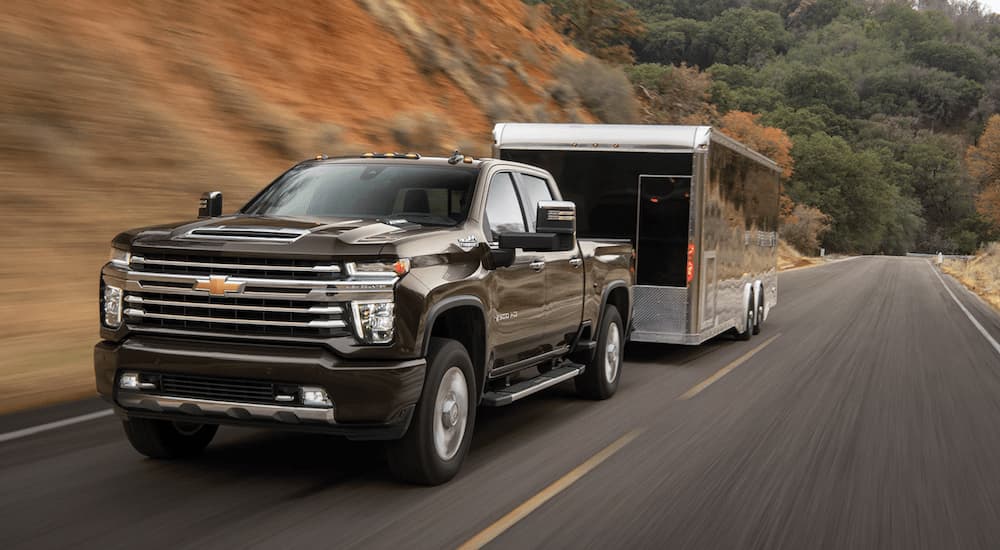 A brown 2023 Chevy Silverado 2500 HD is shown towing a trailer during a 2023 Chevy Silverado 2500 HD vs 2023 Ram 2500 comparison.