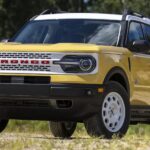 A yellow 2023 Ford Bronco Sport Heritage Limited is shown parked in a field after participating in a 2023 Ford Bronco Sport vs. 2023 Chevy Trailblazer comparison.