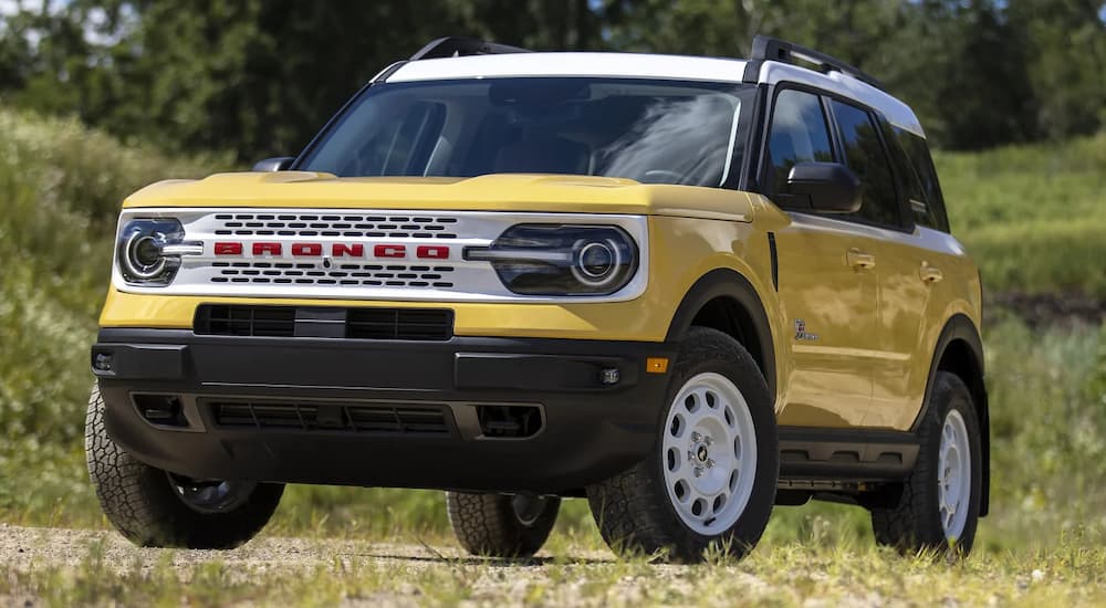 A yellow 2023 Ford Bronco Sport Heritage Limited is shown parked in a field after participating in a 2023 Ford Bronco Sport vs. 2023 Chevy Trailblazer comparison.