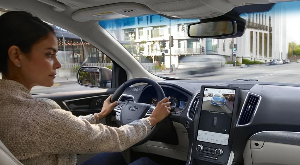 A woman is shown using the Rear View Camera in a 2023 Ford Edge.
