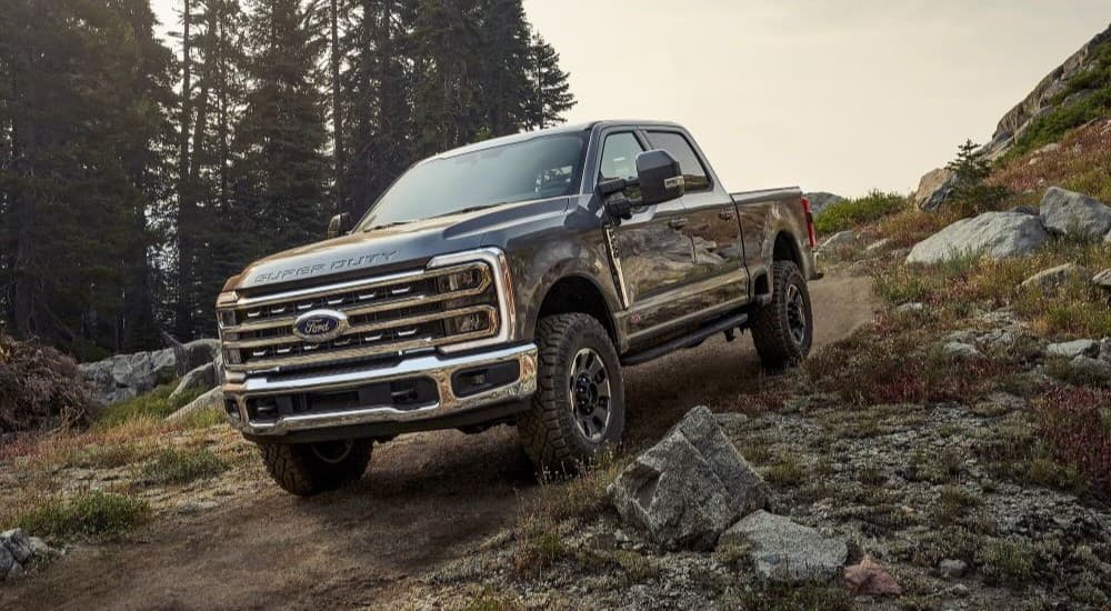 A black 2023 Ford F-250 Tremor is shown driving off-road.