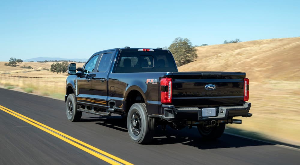 A black 2023 Ford F-250 XL STX is shown from the rear at an angle.