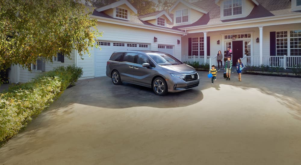 A 2023 Honda Odyssey is shown parked in a driveway.