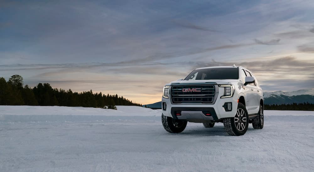 A white 2023 GMC Yukon AT4 is shown from the front at an angle in snow after leaving a GMC dealer.