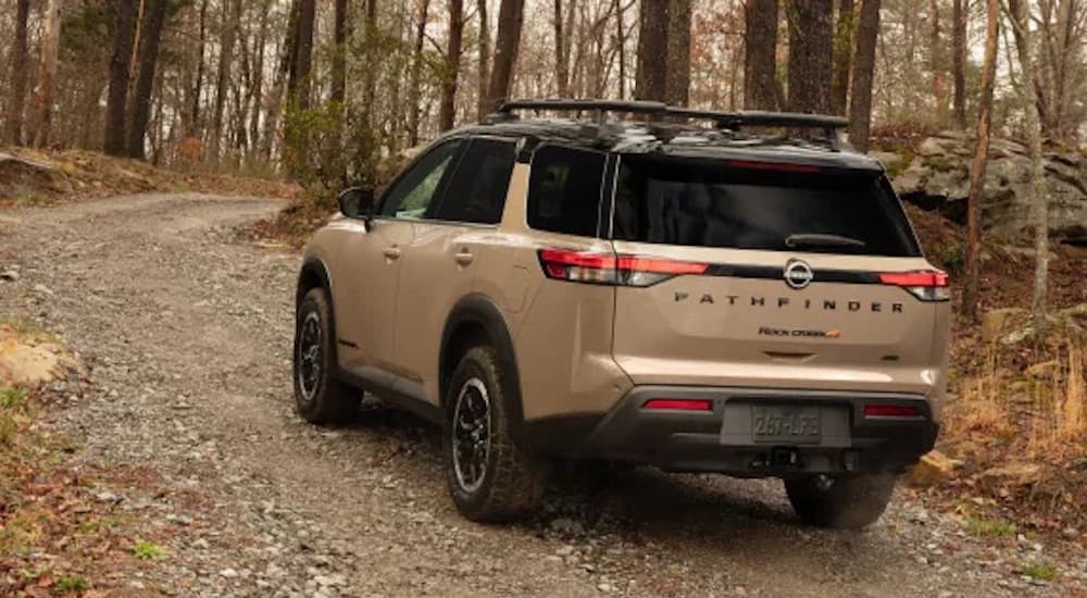 A brown 2023 Nissan Pathfinder Rock Creek is shown from the rear at an angle.