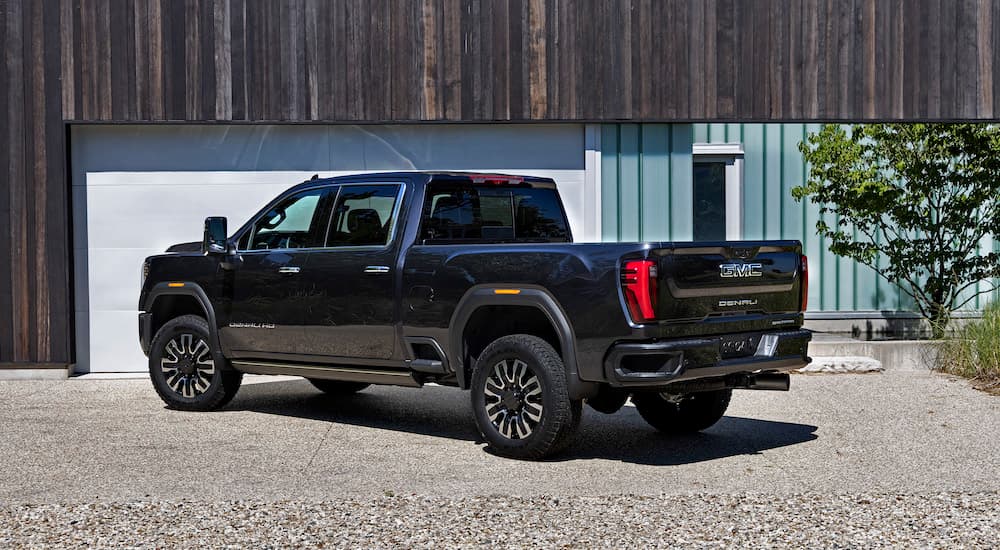 A black 2024 GMC Sierra 2500 HD is shown from the rear at an angle.