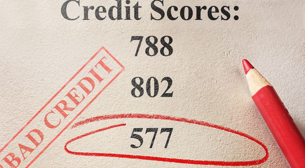 A paper titled "Credit Scores" with the value 577 circled in red with a red stamp next to it that reads "Bad Credit" is shown. 