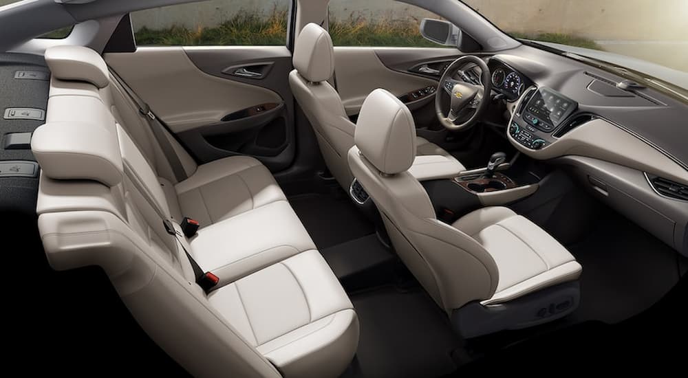 The interior of the 2023 Chevy Malibu is shown with Light Wheat leather seats.