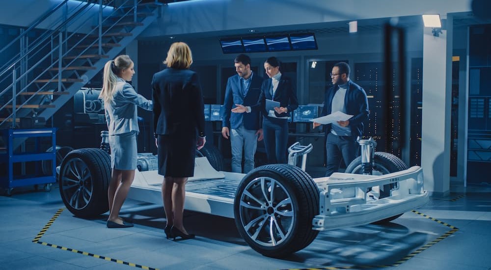 A team of engineers is shown designing a vehicle for Detroit car sales.