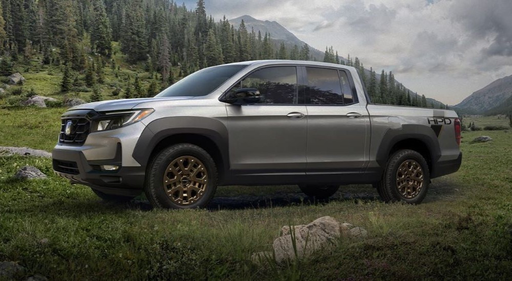 A silver 2023 Honda Ridgeline HPD is shown parked on a field.