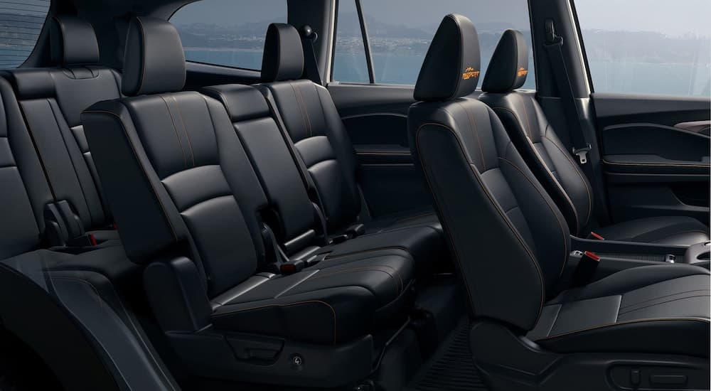 The black interior of a 2022 Honda Pilot Trailsport is shown from the passenger side.