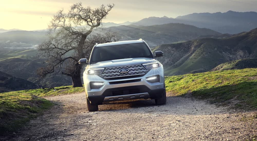A white 2023 Ford Explorer is shown driving on a gravel trail.