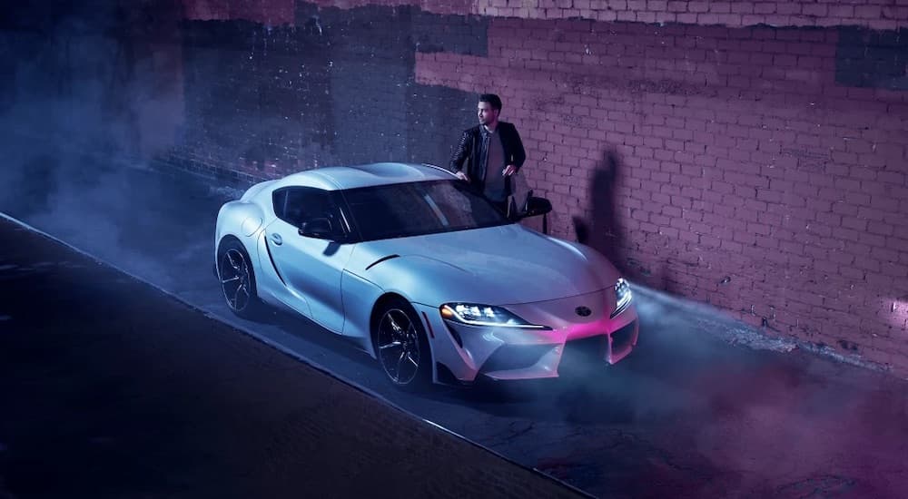 A 2021 Toyota Supra is shown parked on a road next to a building.