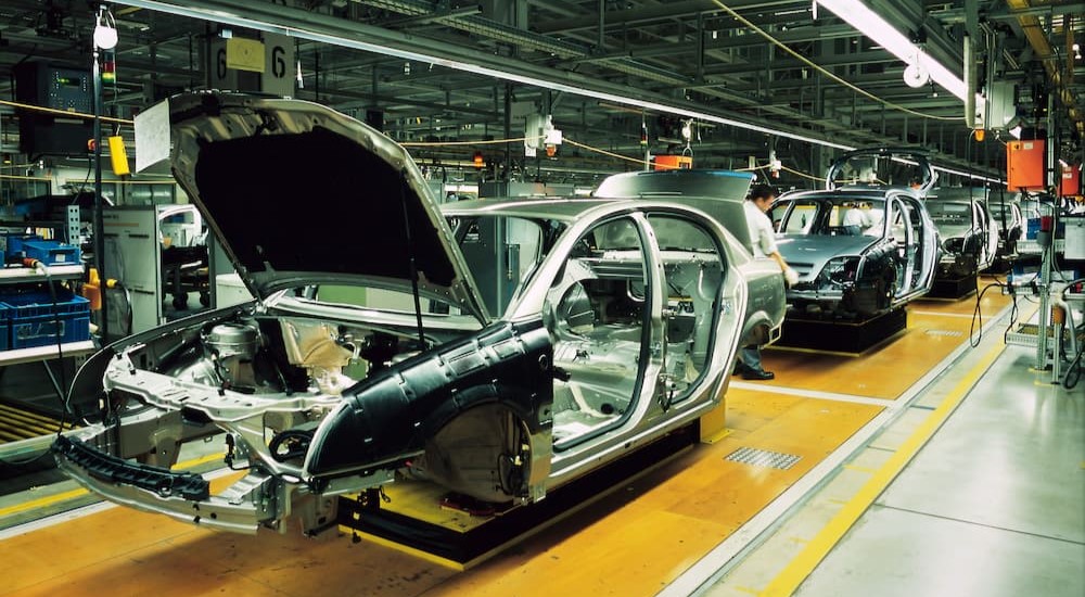 A production line with unfinished cars is shown.