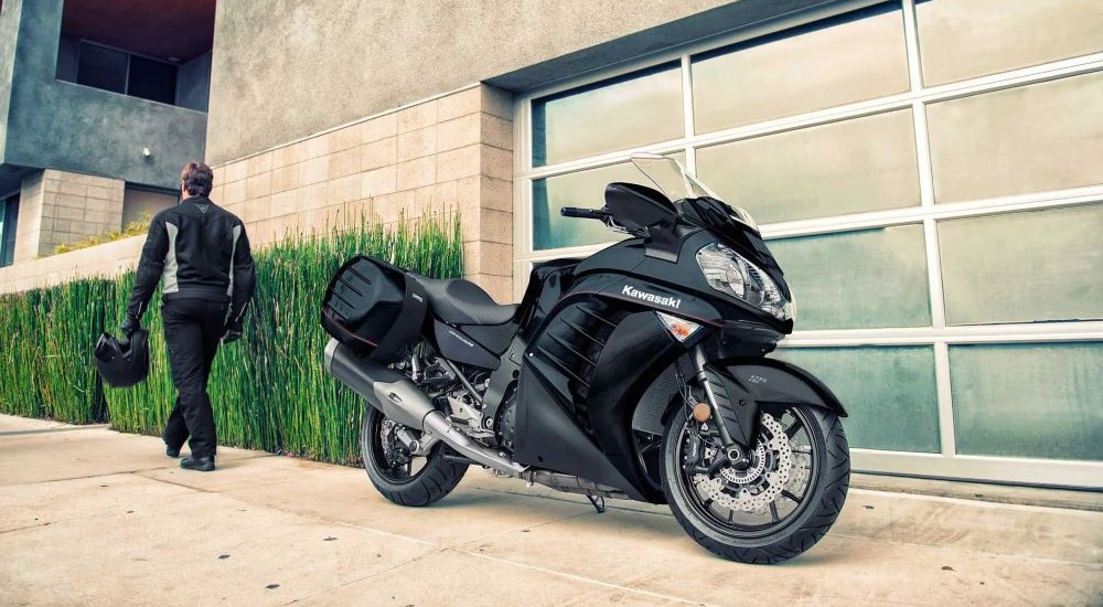 One of the most popular used Kawasaki motorcycles for sale, a 2022 Kawasaki Concours 14 ABS, is shown in front of a garage.