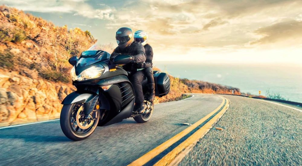 Two people are shown riding a black 2022 Kawasaki Concours 14 ABS.