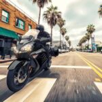 A black 2023 Kawasaki Concours 14 ABS is shown driving down a city street.