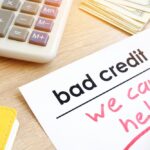 Bad credit we can help' is shown written on a piece of paper.