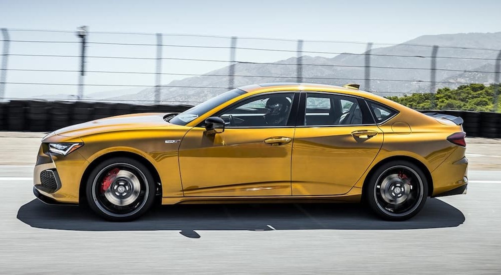 A yellow 2022 Acura TLX Type-S is shown driving on a race track.