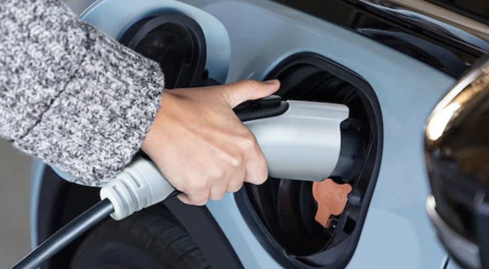 A person is shown charging a 2023 Chevy Bolt EV.