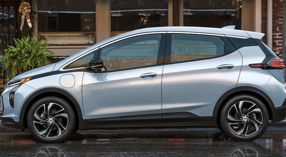 A silver 2023 Chevy Bolt EV is shown parked near a building.