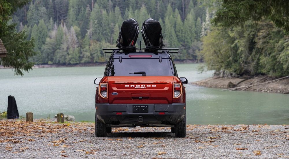 A red 2023 Bronco Sport is shown parked near a lake.